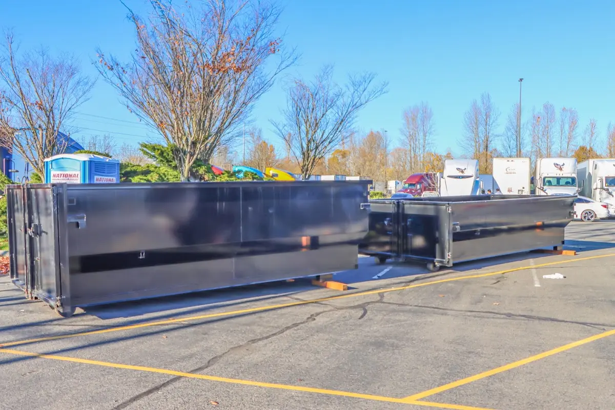 Professional dumpster rental service with roll-off container on residential driveway in Peterborough